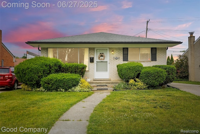 29035 Spoon Ave, Waterford, MI 48071 - bungalow featuring a front yard, brick siding, and roof with shingles