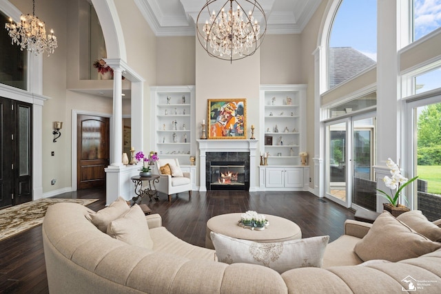 11694 Robinshire St, Temperance, MI 48182 - living area featuring a towering ceiling, a chandelier, a glass covered fireplace, dark wood-style flooring, and ornamental molding