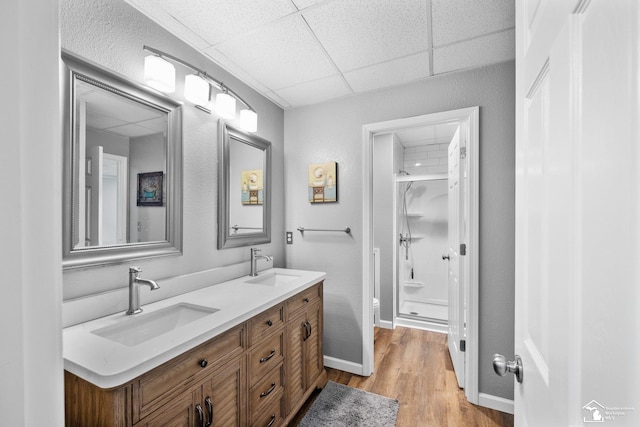 11694 Robinshire St, Temperance, MI 48182 - bathroom featuring double vanity, a shower stall, a drop ceiling, and wood finished floors