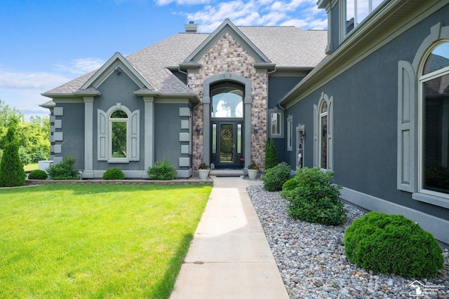 11694 Robinshire St, Temperance, MI 48182 - view of front of house featuring a front yard, stone siding, stucco siding, a chimney, and roof with shingles