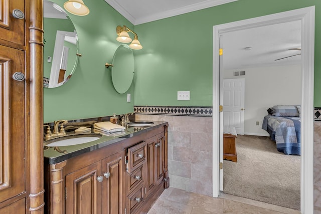 6824 Napoleon Rd, Jackson, MI 49201 - bathroom with double vanity, ornamental molding, ensuite bath, tile walls, and wainscoting