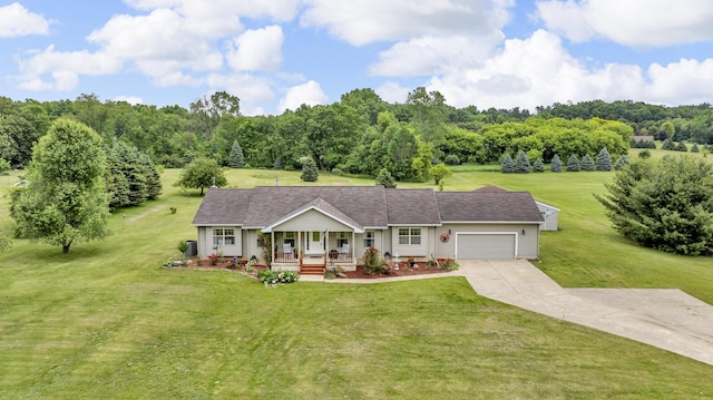 6824 Napoleon Rd, Jackson, MI 49201 - ranch-style home featuring a porch, concrete driveway, an attached garage, and a front yard