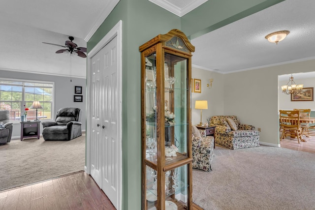 6824 Napoleon Rd, Jackson, MI 49201 - hallway featuring carpet flooring, crown molding, a chandelier, a textured ceiling, and wood finished floors