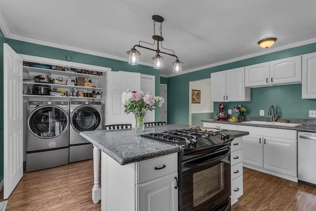 6824 Napoleon Rd, Jackson, MI 49201 - kitchen with washing machine and dryer, black range with gas stovetop, dishwasher, white cabinetry, and ornamental molding