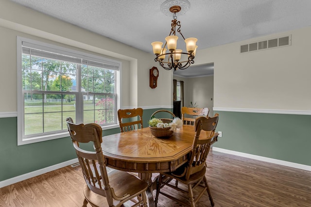 6824 Napoleon Rd, Jackson, MI 49201 - dining area with wood finished floors, healthy amount of natural light, a chandelier, and a textured ceiling