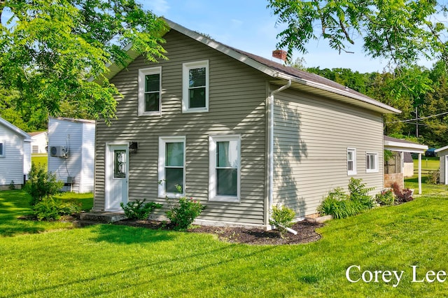 413 W Riverside Dr, Ionia, MI 48846 - rear view of house with a yard and a chimney