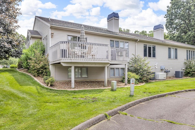 4268 Fairway Ln, Jackson, MI 49201 - back of property with a chimney, a deck, and a lawn