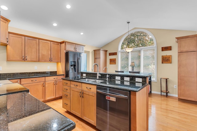 4268 Fairway Ln, Jackson, MI 49201 - kitchen with stainless steel appliances, vaulted ceiling, light wood-type flooring, a kitchen island with sink, and decorative light fixtures