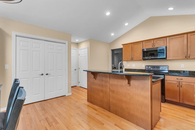 4268 Fairway Ln, Jackson, MI 49201 - kitchen with range with electric cooktop, light wood finished floors, a breakfast bar area, lofted ceiling, and recessed lighting