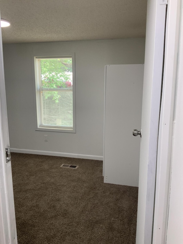 8356 Constitution Blvd, Cadillac, MI 49601 - carpeted spare room with a textured ceiling and baseboards
