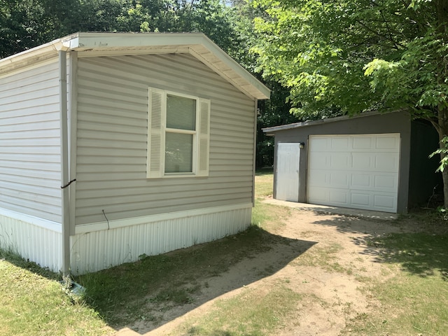 8356 Constitution Blvd, Cadillac, MI 49601 - view of home's exterior featuring an outdoor structure, a detached garage, and driveway
