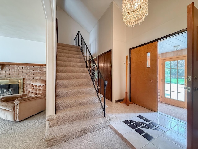 57081 M 51 S, Dowagiac, MI 49047 - entryway with stairs, a chandelier, high vaulted ceiling, light tile patterned flooring, and a fireplace