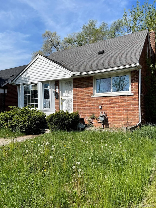 20569 Evergreen Rd, Detroit, MI 48219 - view of front of house featuring a shingled roof and brick siding
