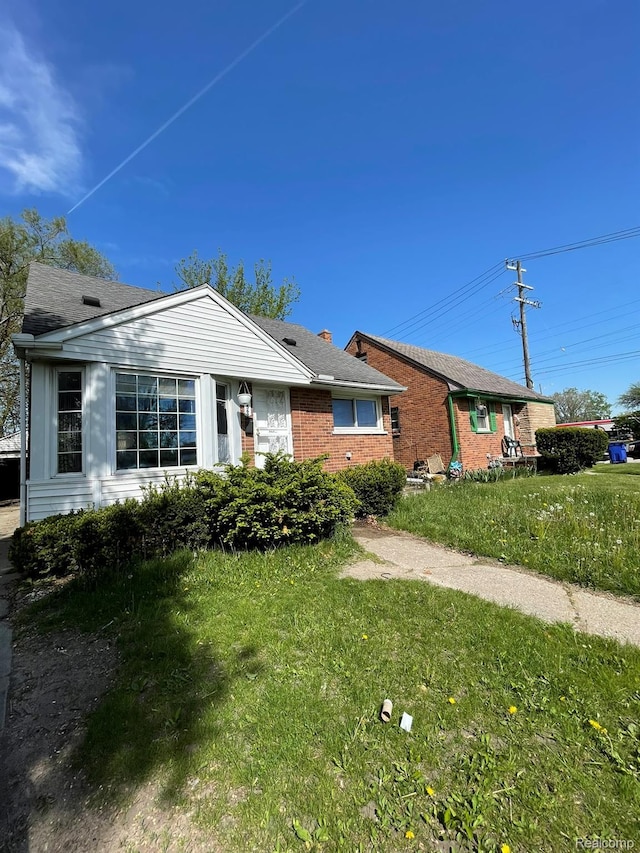 20569 Evergreen Rd, Detroit, MI 48219 - ranch-style home with a front yard, brick siding, and a chimney