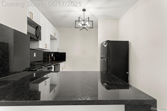 4266 Seminole St, Dearborn, MI 48214 - kitchen featuring black appliances, tasteful backsplash, white cabinets, a chandelier, and dark stone counters