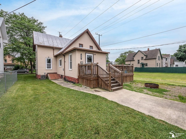 606 E 3rd St, Monroe, MI 48161 - rear view of house with an outdoor fire pit, a metal roof, a standing seam roof, and a deck