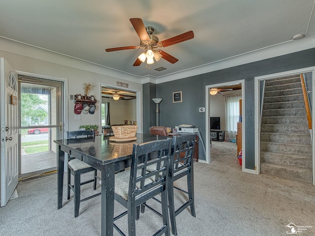 606 E 3rd St, Monroe, MI 48161 - dining space with light carpet, ceiling fan, and stairs