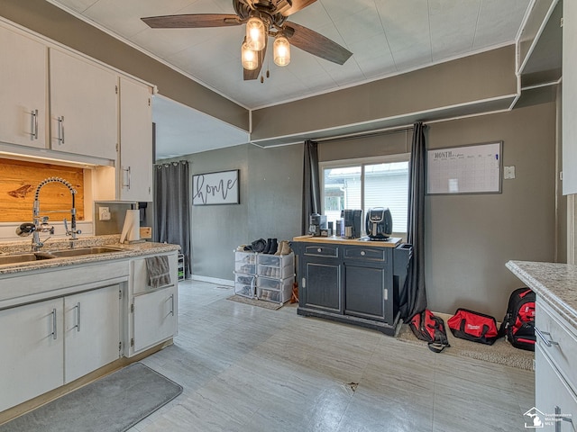 606 E 3rd St, Monroe, MI 48161 - kitchen featuring light countertops, ceiling fan, ornamental molding, and white cabinetry