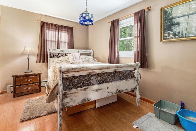 116 E Beech St, Fruitport, MI 49415 - bedroom with wood finished floors and a baseboard radiator