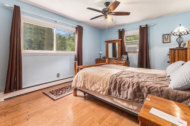 116 E Beech St, Fruitport, MI 49415 - bedroom featuring a baseboard radiator, wood-type flooring, cooling unit, and ceiling fan