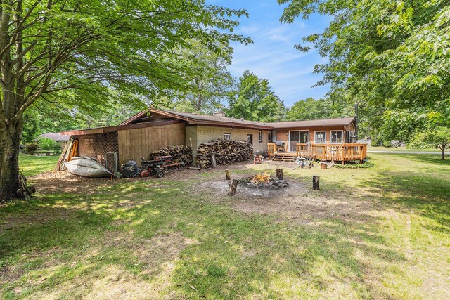 116 E Beech St, Fruitport, MI 49415 - back of property featuring a lawn, a wooden deck, and brick siding