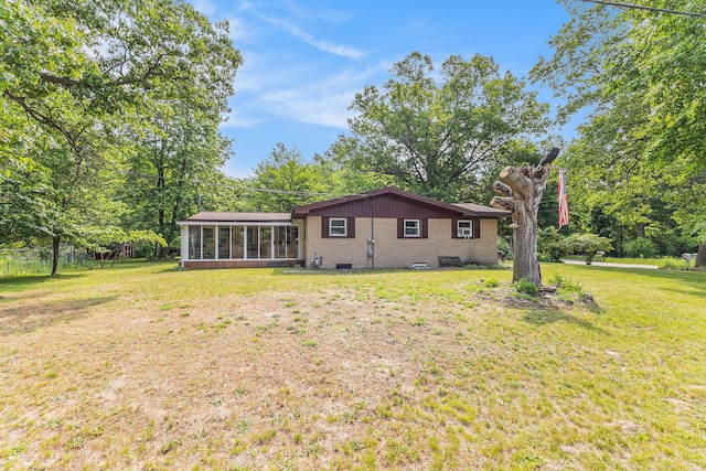 116 E Beech St, Fruitport, MI 49415 - rear view of property featuring a sunroom, a yard, and brick siding