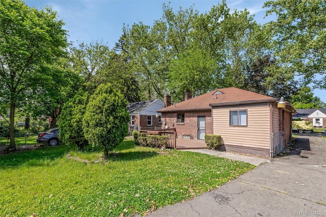 12892 Asbury Park, Detroit, MI 48227 - view of front of home with a front lawn, a chimney, a deck, and brick siding