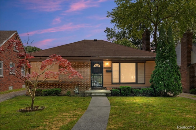12892 Asbury Park, Detroit, MI 48227 - view of front of house with a lawn, brick siding, a chimney, and a shingled roof
