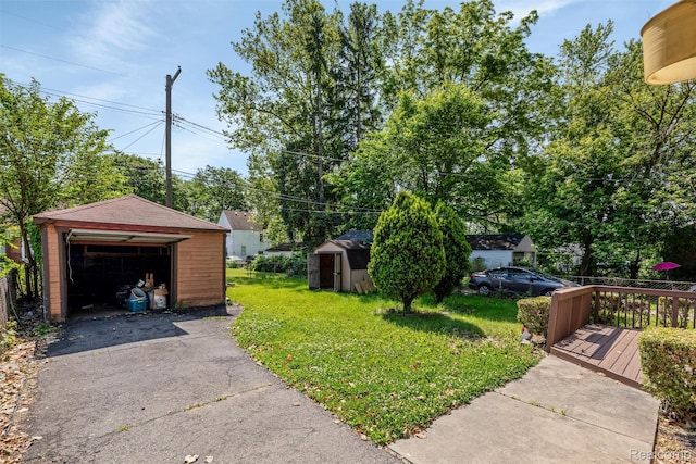 12892 Asbury Park, Detroit, MI 48227 - view of grassy yard featuring a detached garage, a wooden deck, a storage shed, and driveway