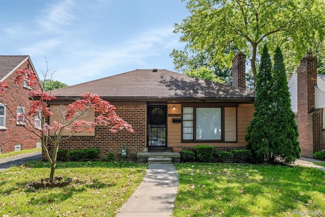 12892 Asbury Park, Detroit, MI 48227 - view of front of house with a front lawn, a chimney, brick siding, and roof with shingles