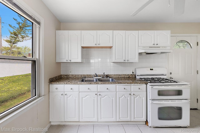 561 E Bennett Ave, Ferndale, MI 48220 - kitchen featuring range with two ovens, under cabinet range hood, white cabinetry, decorative backsplash, and light tile patterned floors