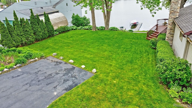4030 Rollins Ave, Waterford, MI 48329 - view of grassy yard with a water view and a patio