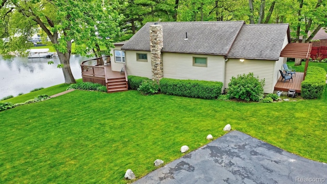 4030 Rollins Ave, Waterford, MI 48329 - rear view of house with a deck with water view, a yard, and a shingled roof