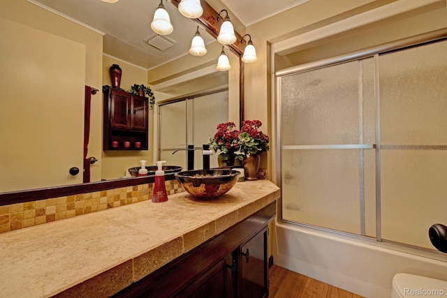 4030 Rollins Ave, Waterford, MI 48329 - bathroom with vanity, combined bath / shower with glass door, crown molding, and wood finished floors