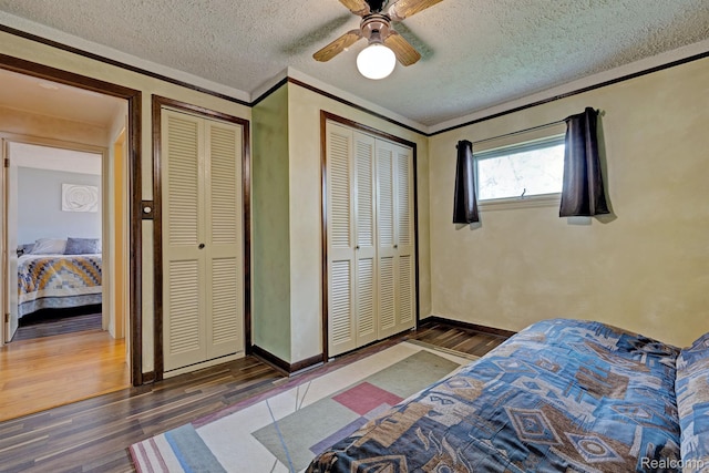 4030 Rollins Ave, Waterford, MI 48329 - bedroom featuring wood finished floors, a textured ceiling, ornamental molding, ceiling fan, and two closets
