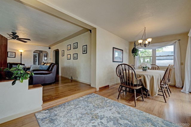 4030 Rollins Ave, Waterford, MI 48329 - dining space featuring arched walkways, a chandelier, wood finished floors, and ceiling fan