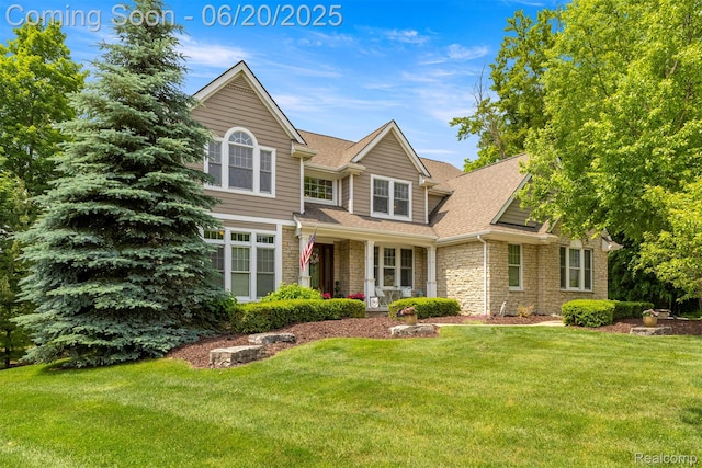23736 Point O Woods Ct, South Lyon, MI 48178 - view of front facade featuring stone siding, a front yard, and a shingled roof