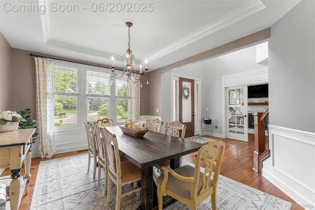 23736 Point O Woods Ct, South Lyon, MI 48178 - dining room featuring a tray ceiling, ornamental molding, a chandelier, and hardwood / wood-style floors