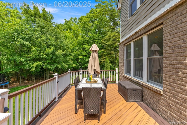 23736 Point O Woods Ct, South Lyon, MI 48178 - wooden deck featuring outdoor dining space and a trampoline