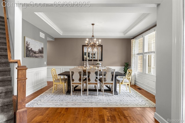 23736 Point O Woods Ct, South Lyon, MI 48178 - dining room featuring stairs, a raised ceiling, wood finished floors, a chandelier, and crown molding