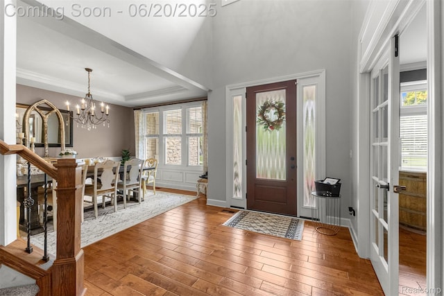 23736 Point O Woods Ct, South Lyon, MI 48178 - foyer entrance with plenty of natural light, a chandelier, wood-type flooring, and crown molding