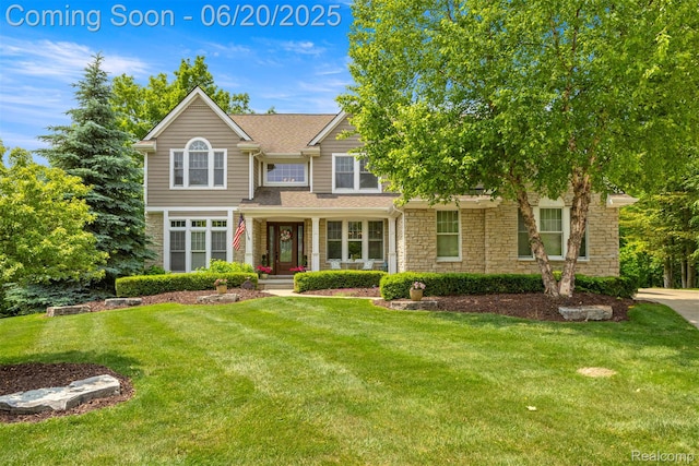 23736 Point O Woods Ct, South Lyon, MI 48178 - view of front facade with a front yard, stone siding, and a shingled roof