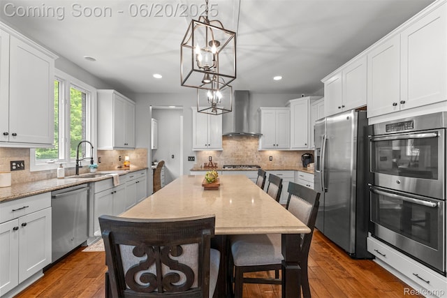 23736 Point O Woods Ct, South Lyon, MI 48178 - kitchen featuring wall chimney range hood, stainless steel appliances, recessed lighting, white cabinets, and wood finished floors