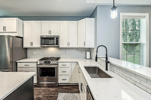 52 Myrtle Ave, Ann Arbor, MI 48103 - kitchen with appliances with stainless steel finishes, light stone countertops, backsplash, white cabinets, and dark wood-style floors