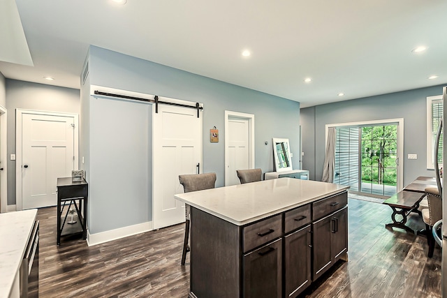 52 Myrtle Ave, Ann Arbor, MI 48103 - kitchen featuring a barn door, a breakfast bar, dark wood-style flooring, dark brown cabinets, and recessed lighting