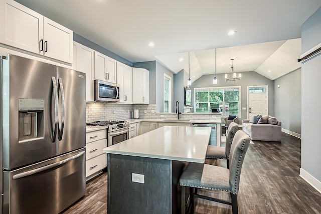 52 Myrtle Ave, Ann Arbor, MI 48103 - kitchen with stainless steel appliances, dark wood finished floors, lofted ceiling, backsplash, and a breakfast bar area
