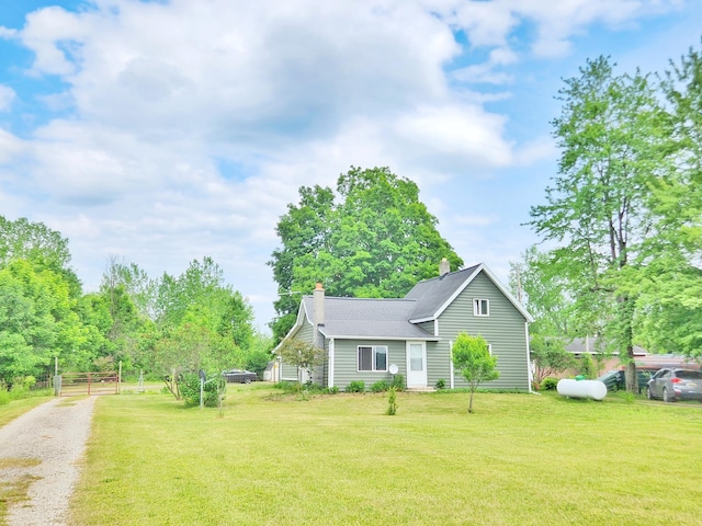 350 S Catalpa Ave, White Cloud, MI 49349 - view of front of house with a chimney, roof with shingles, and driveway