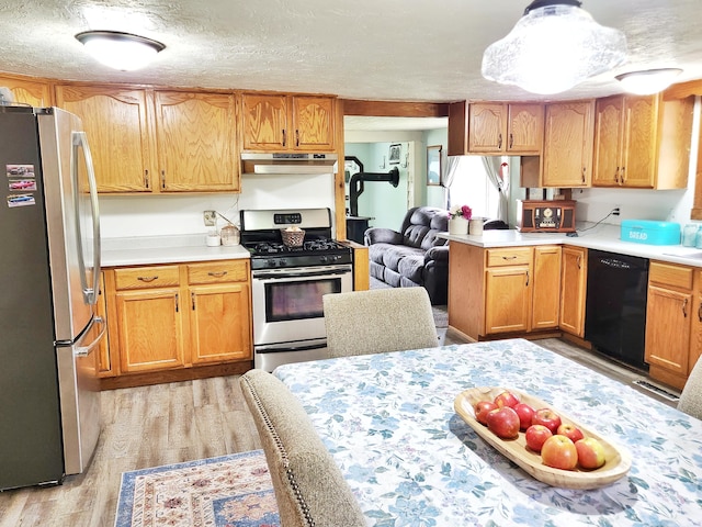 350 S Catalpa Ave, White Cloud, MI 49349 - kitchen with stainless steel appliances, range hood, light wood-type flooring, light countertops, and a textured ceiling
