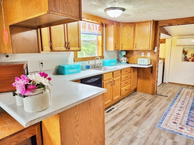 350 S Catalpa Ave, White Cloud, MI 49349 - kitchen featuring light countertops, light wood-style floors, black dishwasher, washer / clothes dryer, and a wall mounted AC