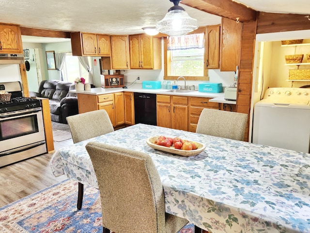 350 S Catalpa Ave, White Cloud, MI 49349 - kitchen featuring stainless steel range with gas cooktop, washer / clothes dryer, dishwasher, light countertops, and light wood-style flooring